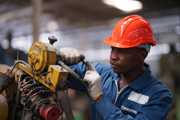 Portrait of Professional Heavy Industry Engineer / Worker Wearing Safety Uniform, Goggles and Hard Hat. In the Background Unfocused Large Industrial Factory