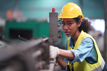 Female apprentice in metal working factory, Portrait of working female industry technical worker or engineer woman working in an industrial manufacturing factory company.