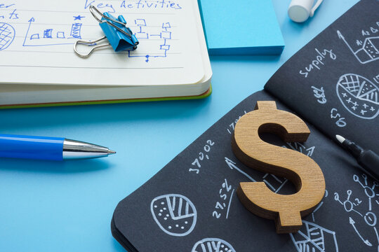 Open notebooks with notes and a dollar sign as a symbol of profit.