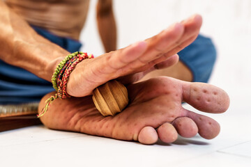 Practice of standing on nails. Sadhu wooden board with nails for sadhu practice. Close-up of a man massaging a foot with imprints from nails