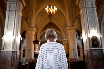 Woman is praying in the church. Religious concept, light of spiritual state