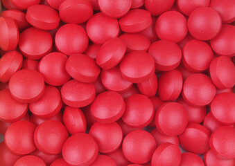 Red drugs background. Many red tablets close up. 