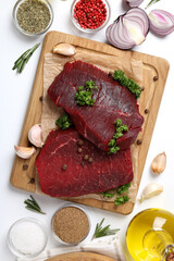 Concept of tasty food with raw beef steaks on white background