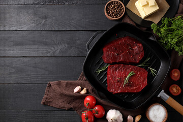 Concept of tasty food with raw beef steaks on dark wooden table