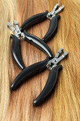 Female hair and hair extension tongs, close up
