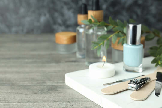 Concept of nail care with manicure accessories on gray wooden table