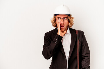 Young architect caucasian man with helmet isolated on white background is saying a secret hot braking news and looking aside