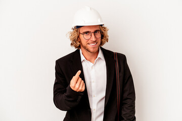 Young architect caucasian man with helmet isolated on white background pointing with finger at you as if inviting come closer.