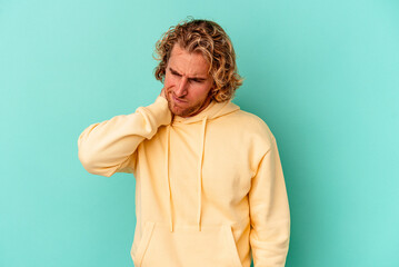 Obraz premium Young caucasian man isolated on blue background having a neck pain due to stress, massaging and touching it with hand.