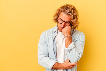 Young caucasian man isolated on yellow background who feels sad and pensive, looking at copy space. - obrazy, fototapety, plakaty