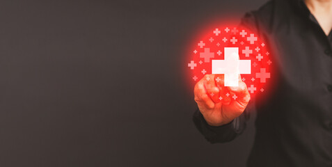 Businesswoman touching at virtual medical health icons while standing against a gray background.