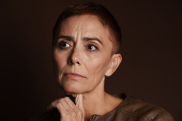 Senior ginger woman with short hair posing and looking aside