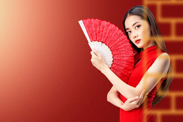 Asian Chinese woman in a cheongsam dress holding fan celebrates Chinese New Year