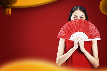 Asian Chinese woman in a cheongsam dress holding fan celebrates Chinese New Year