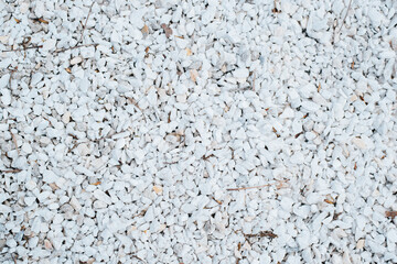 Small white decorative smooth stones outdoors, top view. Texture stone background
