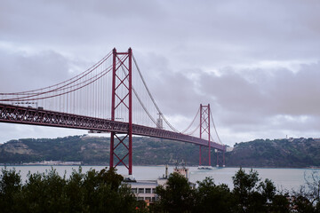 Beautiful landscape with suspension 25 April bridge bridge over the Tagus river in Lisbon, Portugal.