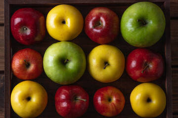 Colorful apples. Red, yellow and green apples on a wooden tray