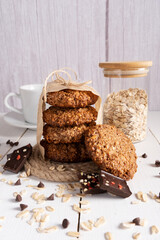 Homemade oatmeal cookies with chocolate and nuts tied with jute thread on baking paper