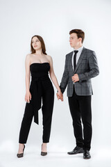 portrait of a young couple in suits on white background.