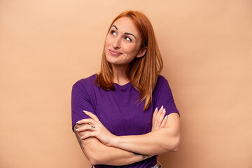 Obraz premium Young caucasian woman isolated on beige background dreaming of achieving goals and purposes