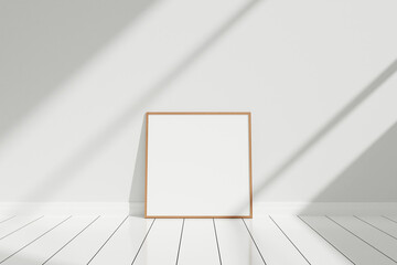 Minimalist and clean square wooden poster or photo frame mockup on the floor leaning against the...