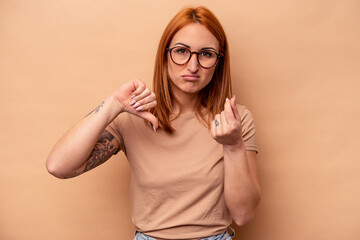 Fototapeta premium Young caucasian woman isolated on beige background showing that she has no money.