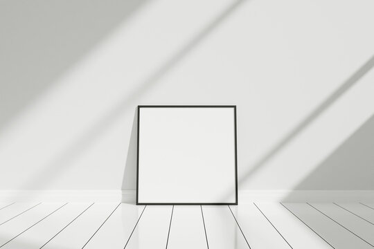 Minimalist and clean square black poster or photo frame mockup on the floor leaning against the room wall with shadow