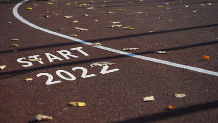Sign Start 2022 Empty sports field with running track markings used in outdoor tennis in autumn...