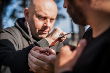 Knife vs knife fight. Kapap instructors demonstrates sombrada drill training