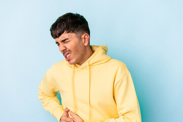 Young mixed race man isolated on blue background having a liver pain, stomach ache.