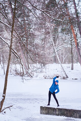 Healthy lifestyle. Young strong man is exercising at snowy park.