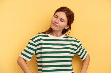 Young English woman isolated on yellow background dreaming of achieving goals and purposes