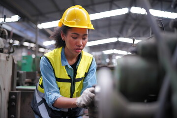 Fototapeta premium Female apprentice in metal working factory, Portrait of working female industry technical worker or engineer woman working in an industrial manufacturing factory company.
