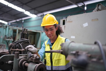 Female apprentice in metal working factory, Portrait of working female industry technical worker or engineer woman working in an industrial manufacturing factory company.