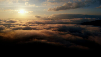 Aerial view: Over Clouds on Sun Rise in Mountains.