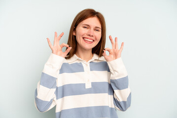 Young English woman isolated on blue background cheerful and confident showing ok gesture.