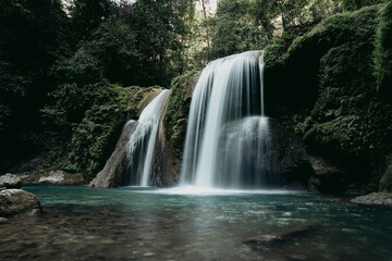 Obraz premium A beautiful large waterfall in the middle of a deep forest, a tropical rainforest in northern Thailand.