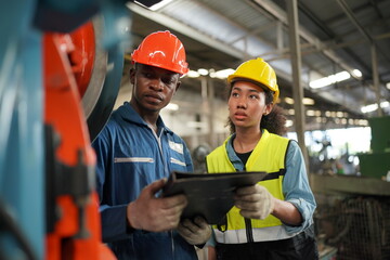 Portrait of Professional Heavy Industry Engineer / Worker Wearing Safety Uniform, Goggles and Hard Hat. In the Background Unfocused Large Industrial Factory