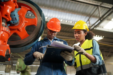 Portrait of Professional Heavy Industry Engineer / Worker Wearing Safety Uniform, Goggles and Hard Hat. In the Background Unfocused Large Industrial Factory