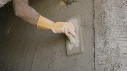 Close up shot unrecognizable construction labor plastering wall and using plaster tools at workplace - concept of home repair service, daily wagers lifestyle and blue coller jobs