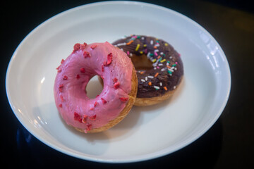 Strawberry and chocolate donuts on plate