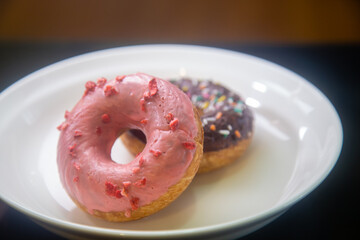 Strawberry and chocolate donuts on plate