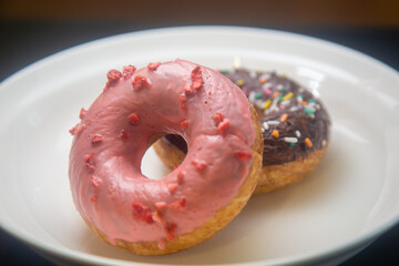 Strawberry and chocolate donuts on plate