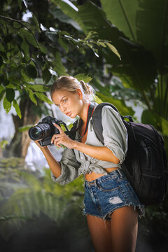 portrait of nice young woman is taking picture in the jungle
