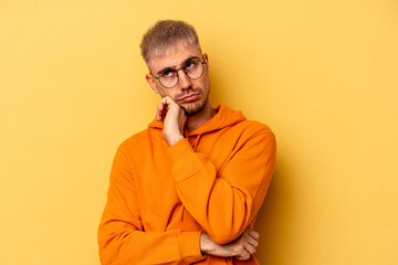 Young caucasian man isolated on yellow background tired of a repetitive task.