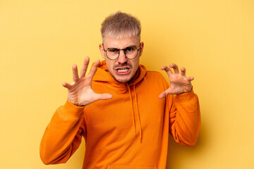Young caucasian man isolated on yellow background upset screaming with tense hands.