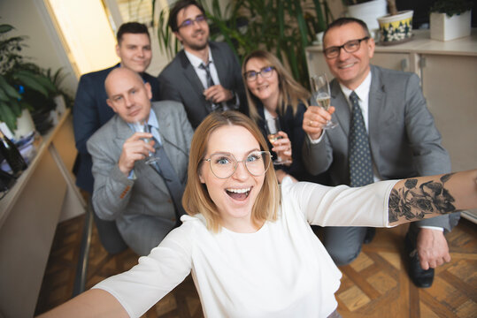 Happy business people team with champagne glasses taking selfie at business meeting