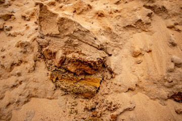 Textural sand, with  relief surface, multi-colored layers and different in size of granules, in outdoor sand career, after mining ore and sand for construction.