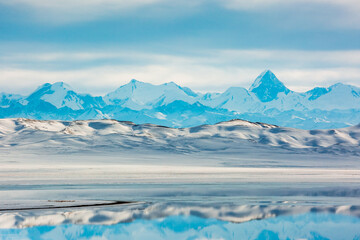 Fototapeta na wymiar Khan Tengri Peak. Tian Shan Mountains. Tuzkol lake of Kazakhstan. Winter mountains landscape
