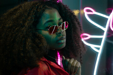 portrait of a beautiful young woman with glasses in futuristic neon light